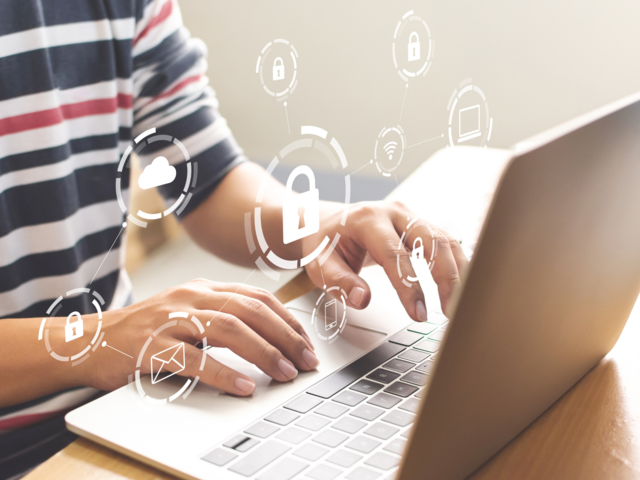 Nahaufnahme von Händen die an einem Laptop schreiben 