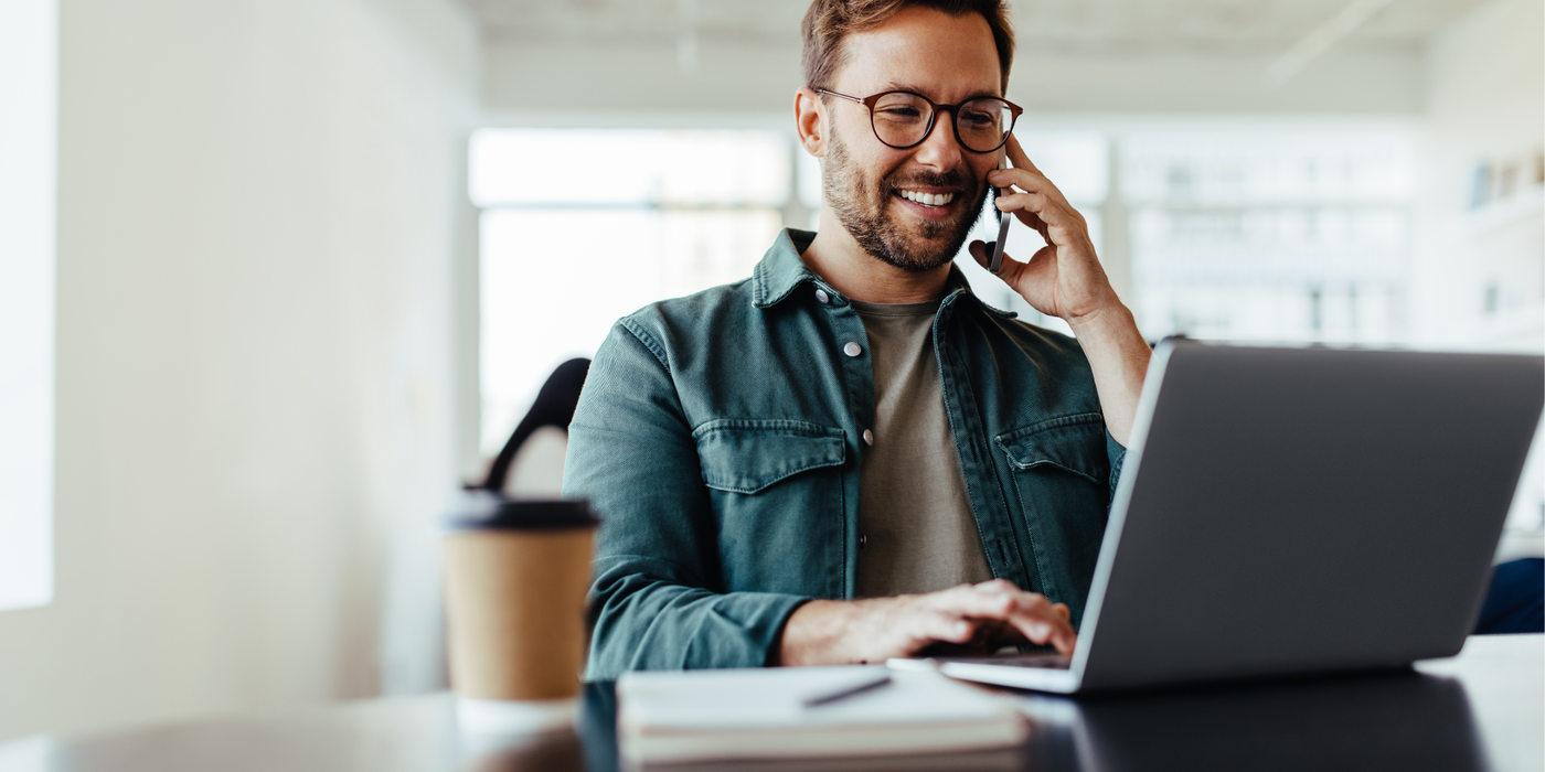 Mitarbeiter telefoniert und arbeitet am Laptop – Symbol für flexible Business-Tarife, zuverlässiges Internet und moderne Kommunikation über Glasfaser für Unternehmen.