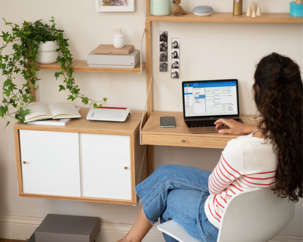 Frau am Tisch mit Laptop und Router