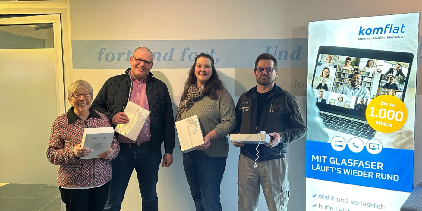 Vier Personen halten gewonnenes IPAD in der Hand