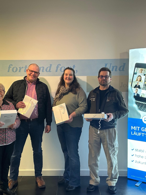 Vier Personen halten gewonnenes IPAD in der Hand