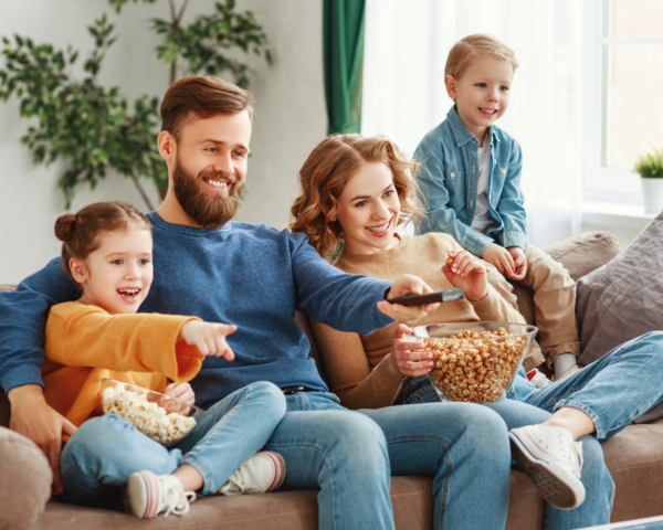 Familie auf dem Sofa mit Fernbedienung Familie auf dem Sofa mit Fernbedienung