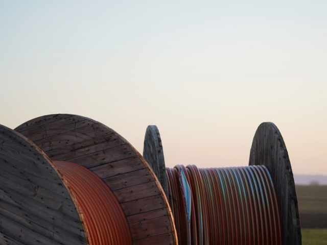 Kabeltrommeln mit Leerrohren auf einem Feld