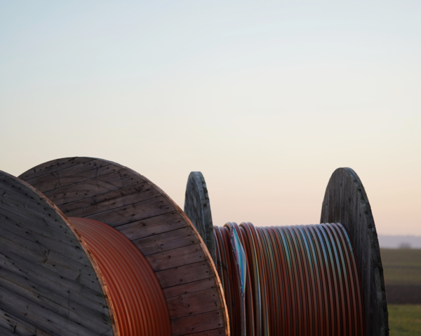 Kabeltrommeln mit Leerrohren auf einem Feld