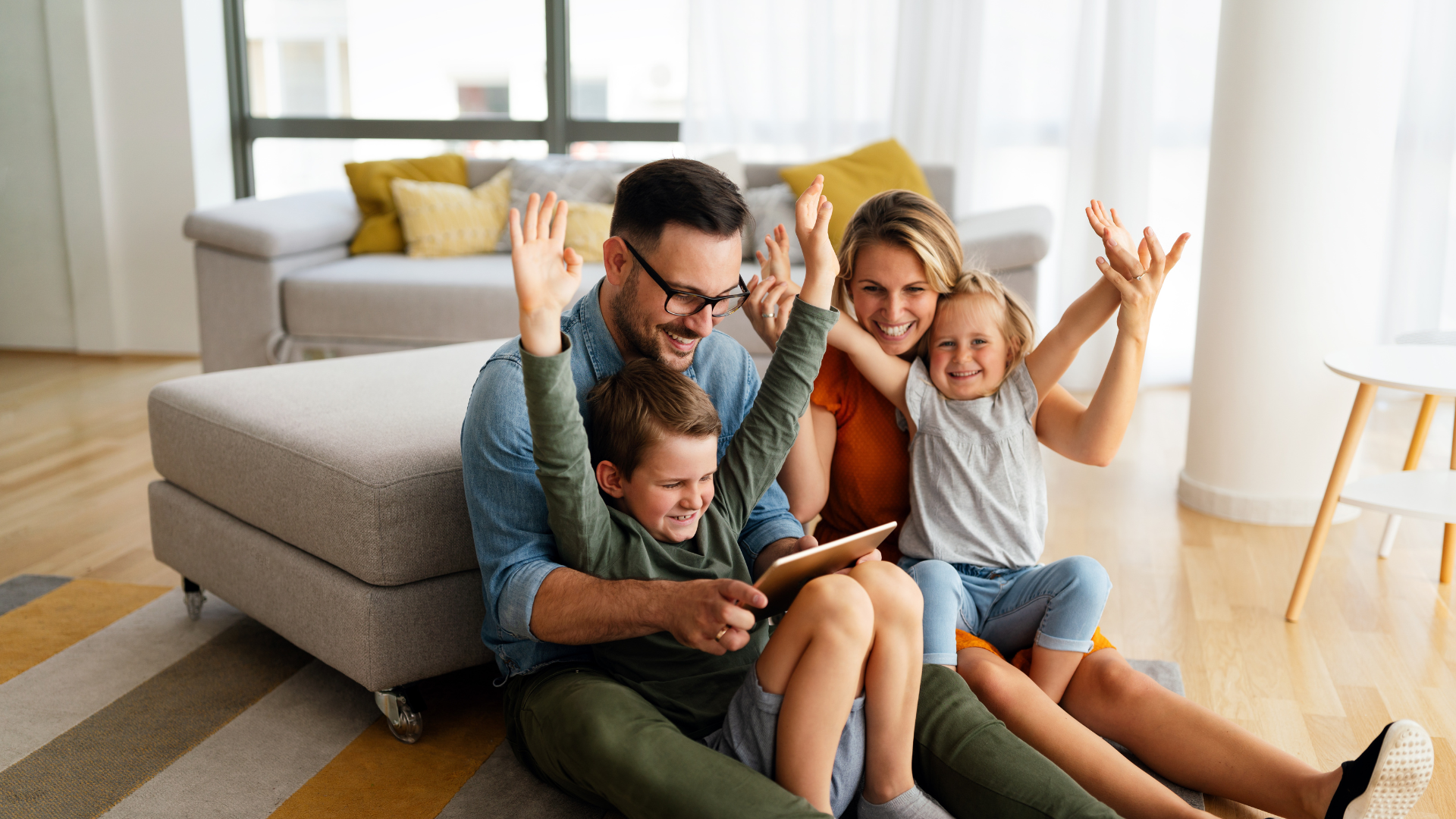 Eine Familie sitzt gemeinsam im Wohnzimmer und nutzt ein Tablet. Das Bild steht sinnbildlich für einen sicheren und entspannten Umgang mit digitalen Geräten – passend zum G DATA Sicherheitspaket und dem sicheren Start ins neue Jahr.
