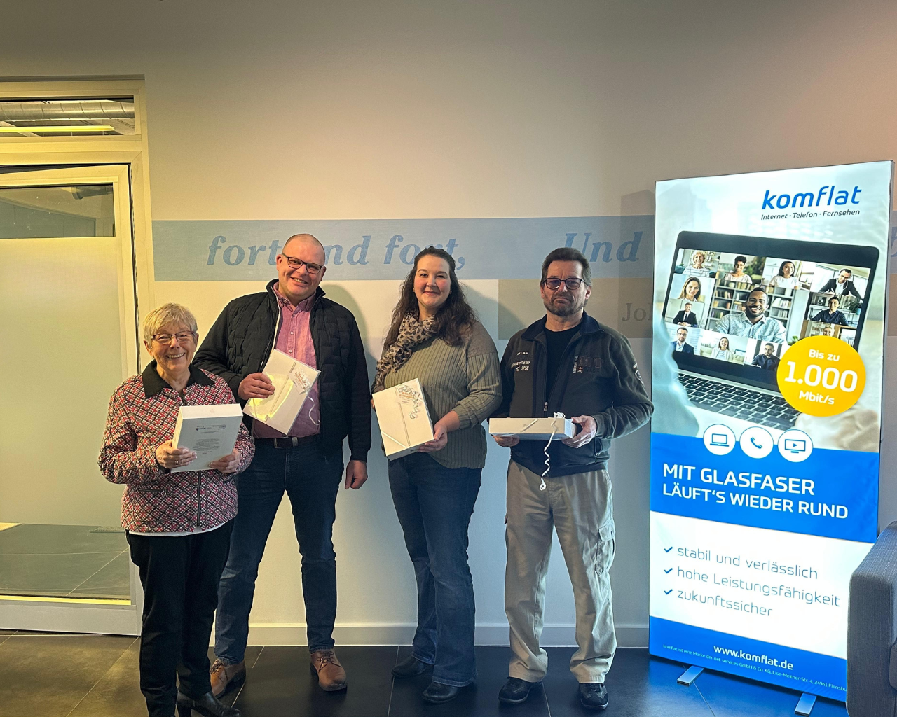 Vier Personen halten gewonnenes IPAD in der Hand